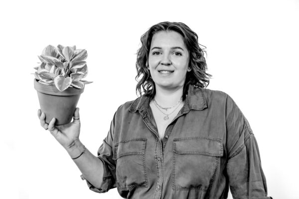 Mandy van Ree recruiter HRM, foto lachend vooraanzicht, potje met plant in de hand