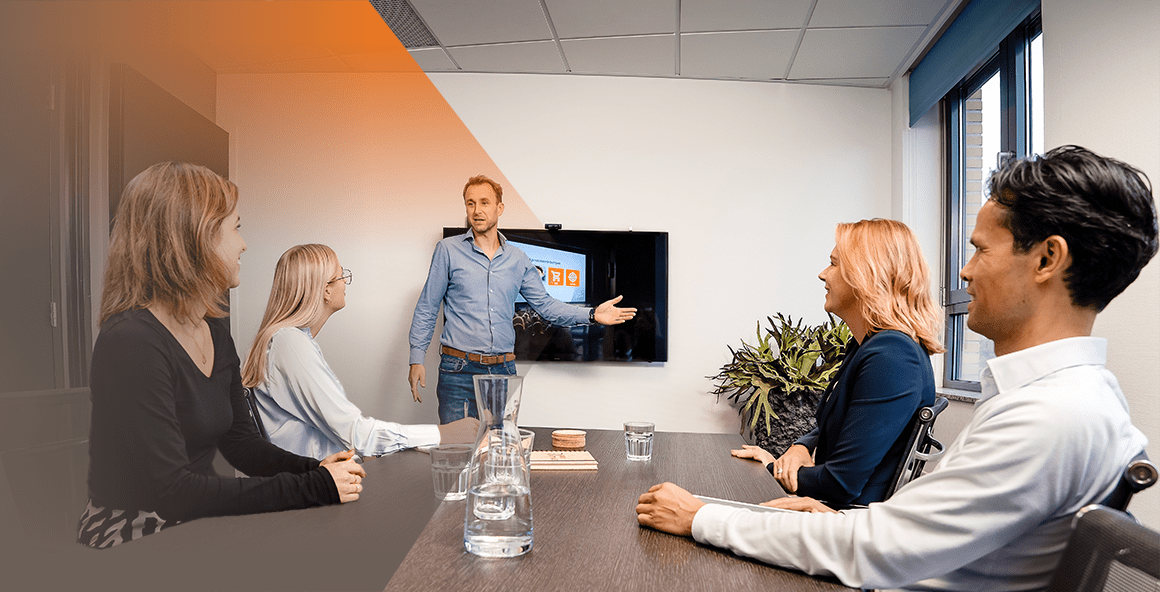 vier collega's kijkend naar een presentatie van een presenteerde